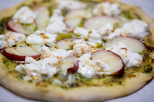 Estate pizza from the Incanto menu with peaches, burrata, and pesto sauce