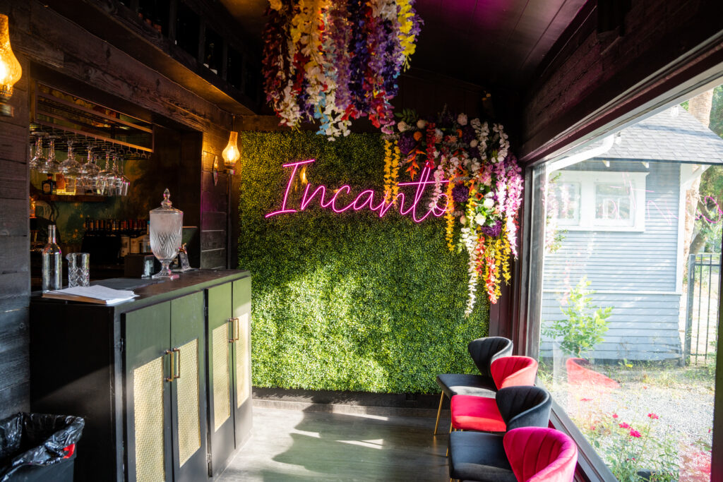 Incanto cocktail lounge in The Heights with floral ceiling and neon sign