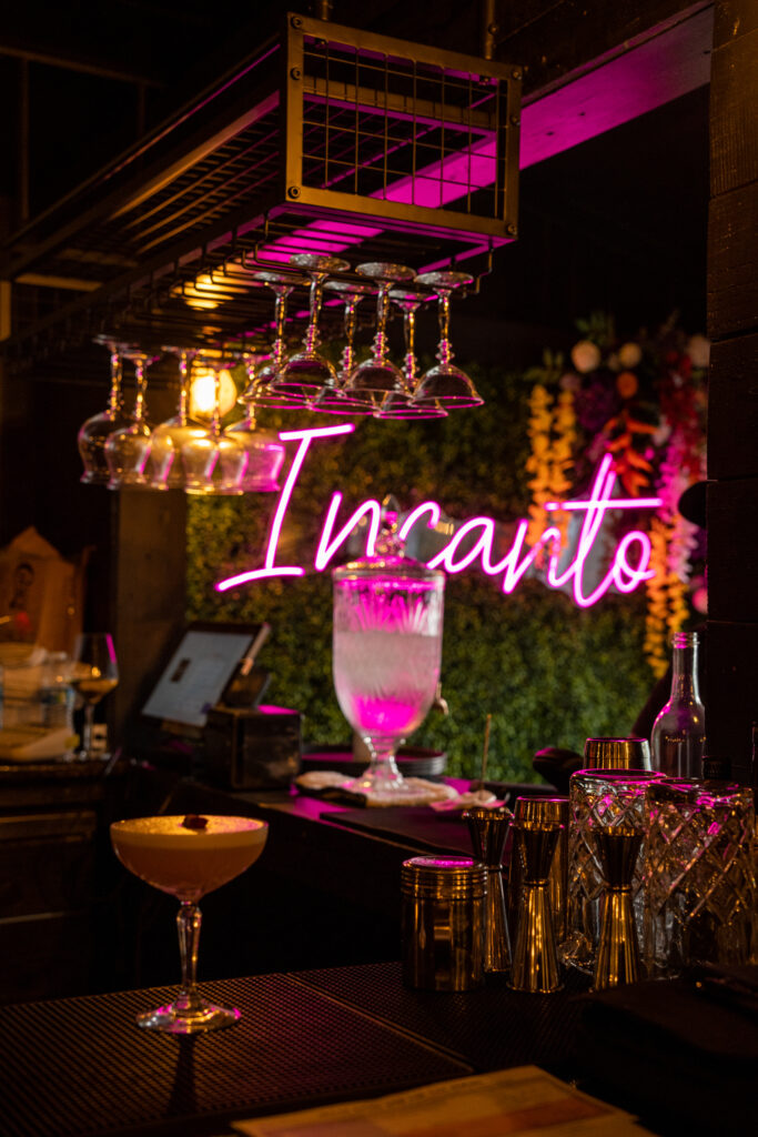 Incanto Houston blog hero image with cocktails and neon sign in The Heights