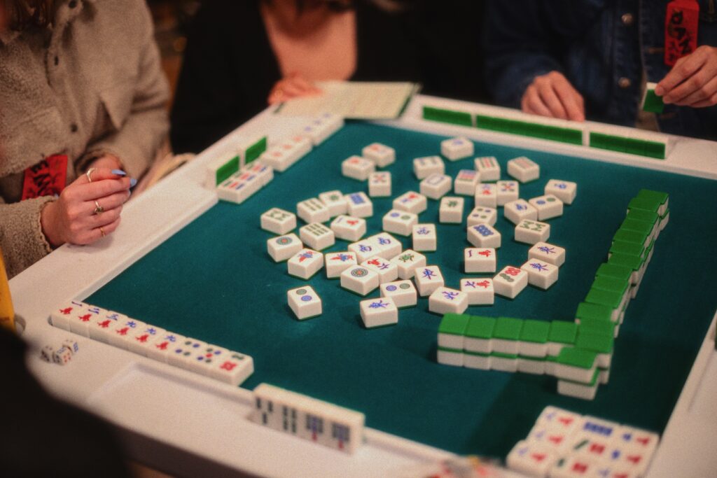 Mahjong tiles on a green table during game night at a Heights cocktail bar